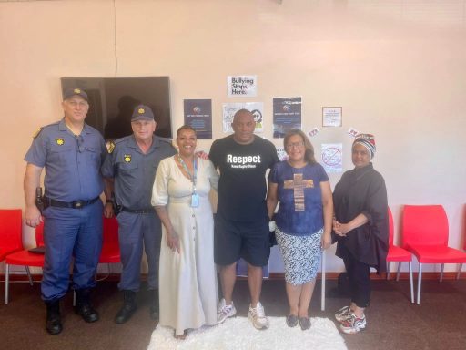 A group of six people, including police officers and civilians, standing together in a room.