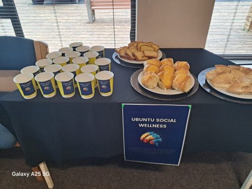 Beverage cups and plates of pastries on a table for an event.