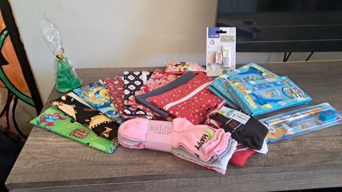 A variety of items including clothes, grooming products, and a decorative object on a table.